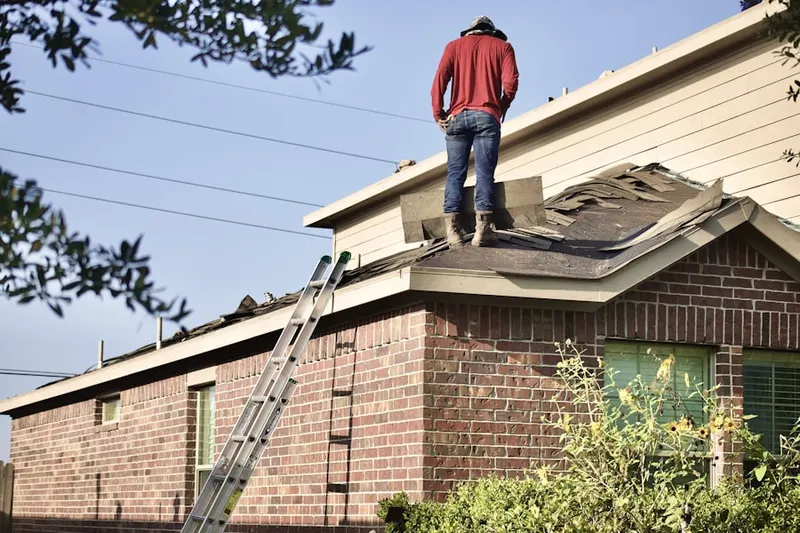 Professional roofer working on a residential roof in Wharton